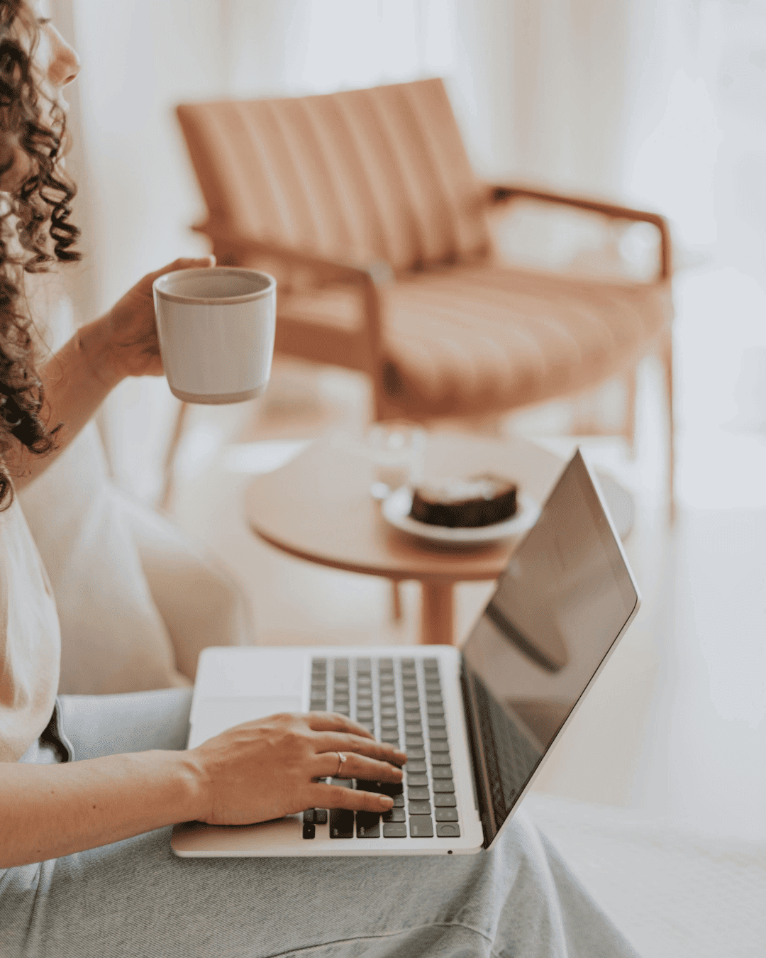 Mujer trabajando en portátil con café, planificando horarios de publicación en Instagram